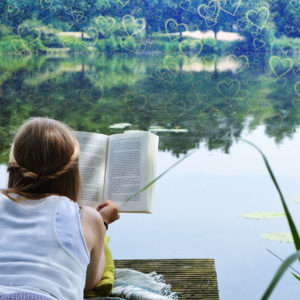 Lesbische Frau liegt am See und liest
